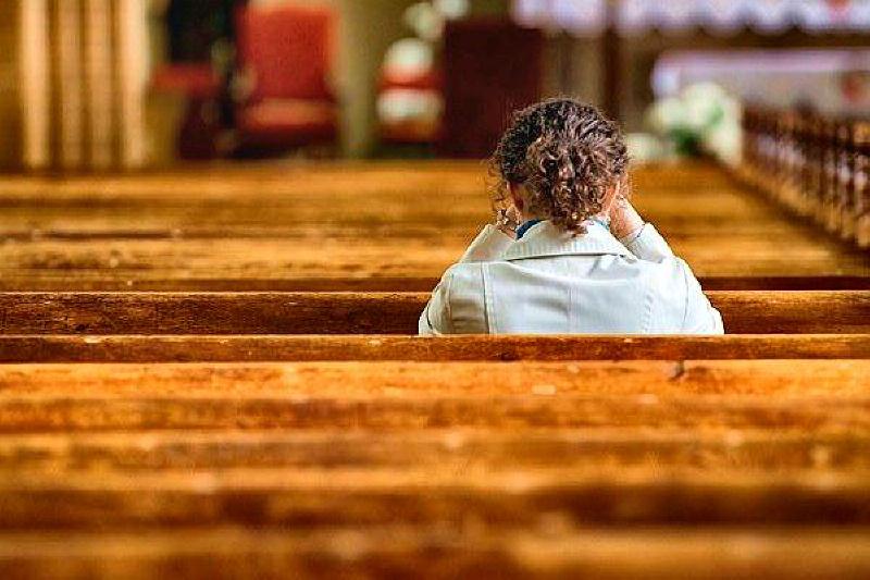 woman in church maybe crying and praying docu